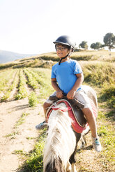 Spanien, Cerdanya, Porträt eines kleinen Jungen, der auf einem Pony reitet - VABF01630