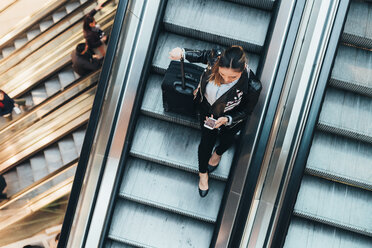 Frau auf Rolltreppe, mit Koffer, Draufsicht - CUF45189