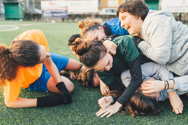 Football players jubilant and hugging on pitch - CUF45228