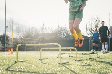 Football player jumping over hurdles - CUF45246