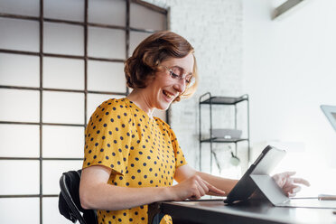 Businesswoman using digital tablet smiling - CUF45269