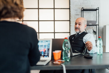 Kollegen im Büro benutzen Laptops, chatten - CUF45278