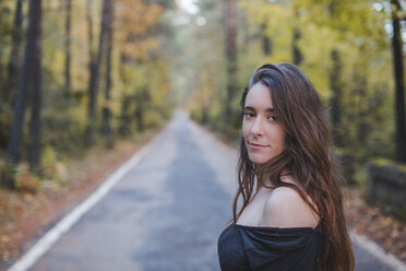 Portrait of smiling young woman on country road - AFVF01645