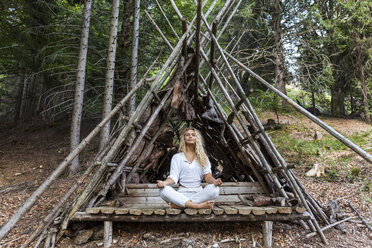 Young woman doing yoga at a shelter in forest - TCF05855