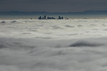 Silhouetted skyscraper buildings above clouds, Vancouver, British Columbia - FSIF03198