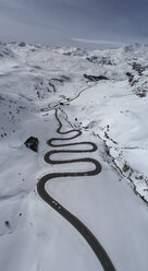 Blick von oben auf eine kurvenreiche Straße durch einen schneebedeckten Berg, St. Moritz, Schweiz - FSIF03219