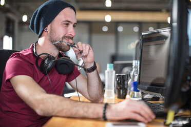 Young man working at his computer in office - CUF45513