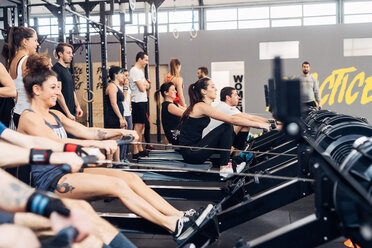 Große Gruppe von Menschen an einem Rudergerät in einem Fitnessstudio - CUF45552