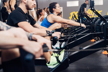 Large group of people using rowing machine in gym - CUF45554