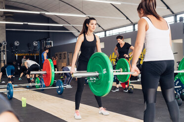 Women weightlifting with barbells in gym - CUF45555