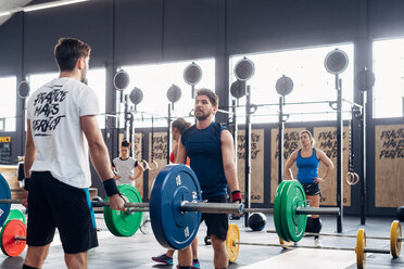 Männer beim Gewichtheben mit Hanteln im Fitnessstudio - CUF45559