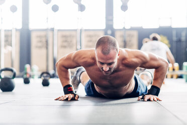 Mann macht Liegestütz im Fitnessstudio - CUF45565