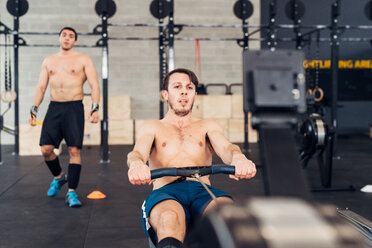 Mann im Fitnessstudio mit Rudergerät - CUF45572