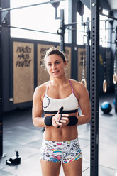 Porträt einer Frau im Fitnessstudio mit Blick in die Kamera - CUF45587