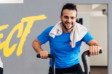 Man in gym using exercise bike - CUF45588