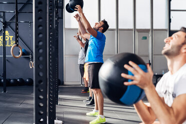 Gruppe von Menschen im Fitnessstudio mit Medizinbällen - CUF45589