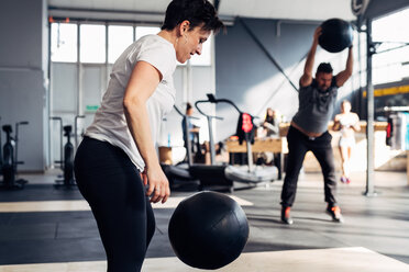 People in gym using medicine ball - CUF45598