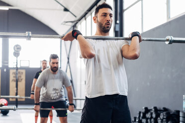 Man weightlifting with barbell in gym - CUF45600