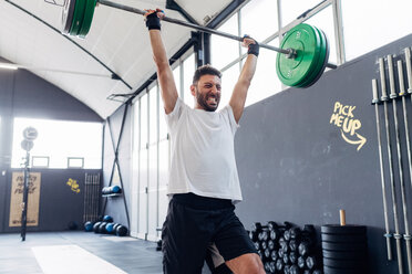 Mann hebt eine Langhantel im Fitnessstudio - CUF45611