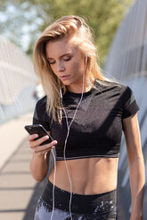 Young woman listening to music on mobile phone - CUF45637
