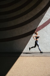 Junge Frau läuft, gemusterter Hintergrund - CUF45644