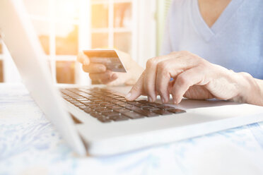 Cropped view of woman holding credit card using laptop - CUF45744