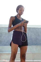 Young woman listening to music on mobile phone - CUF45810