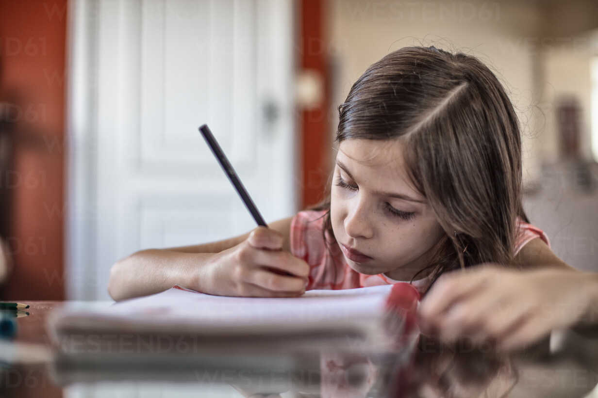 Girl writing at table stock photo