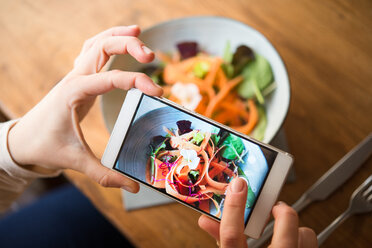 Frau, die eine vegane Mahlzeit fotografiert - CUF45864