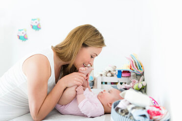 Mother playing with baby on changing table - CUF45876