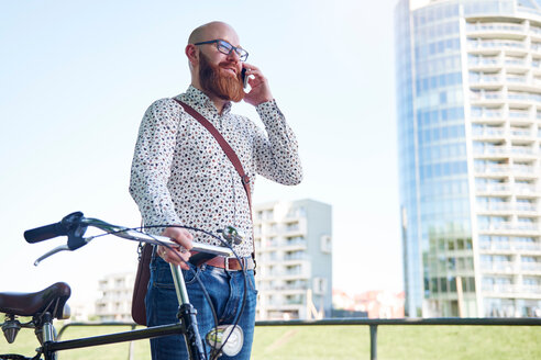 Man with bicycle making telephone call - CUF45935