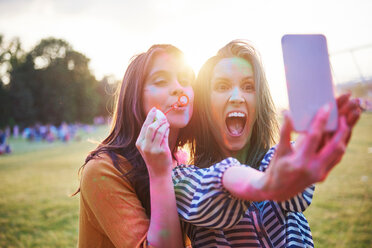 Zwei junge Frauen, die mit farbigem Kreidepulver bedeckt sind, machen ein Selfie beim Holi-Festival - CUF45963