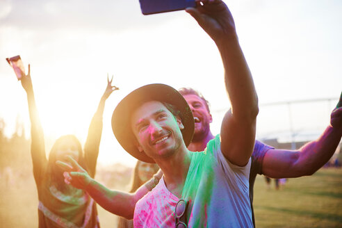 Vier junge erwachsene Freunde, bedeckt mit farbigem Kreidepulver, machen ein Selfie beim Holi Festival - CUF45966