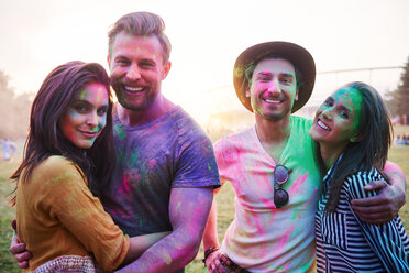 Four young adult friends covered in coloured chalk powder at Holi Festival, portrait - CUF45968