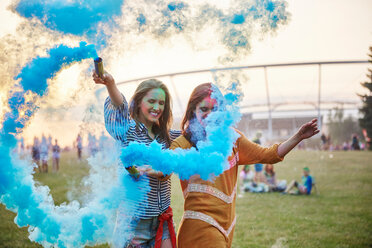 Zwei junge Frauen tanzen mit blauen Rauchbomben beim Holi-Festival - CUF45972