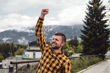 Happy man making a fist in mountain village, Dolenci, Slovenia - CUF45989