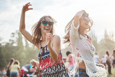 Freunde tanzen mit erhobenen Armen auf einem Musikfestival - CUF45999