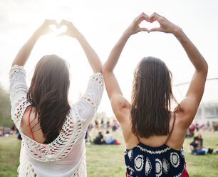 Freunde tanzen mit erhobenen Armen auf einem Musikfestival - CUF46000