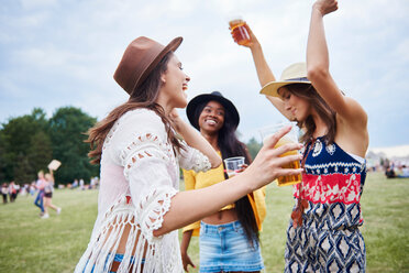 Freunde trinken und tanzen mit erhobenen Armen auf einem Musikfestival - CUF46004