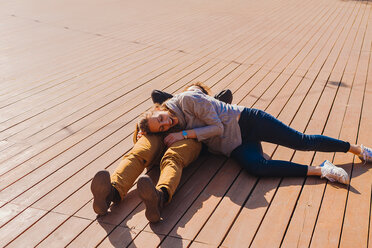 Ehepaar entspannt sich auf einer Holzterrasse - CUF46047