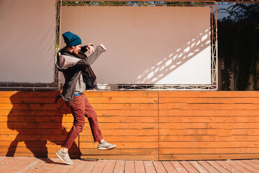 Hipster tanzt auf einer Holzterrasse vor der Bühne - CUF46049