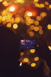 Silhouette einer Frau, die auf dem Christams-Markt ein Foto mit ihrem Smartphone macht - MMAF00615