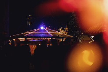 Deutschland, Silhouetten von Menschen auf dem beleuchteten Weihnachtsmarkt - MMAF00618