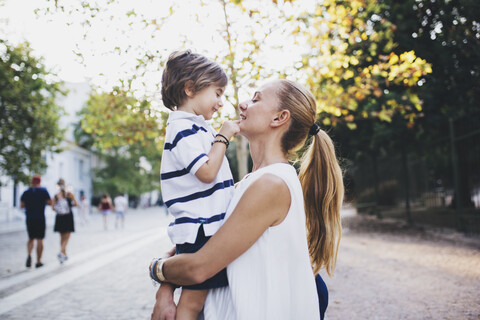 Mother standing in the city, holding her son stock photo