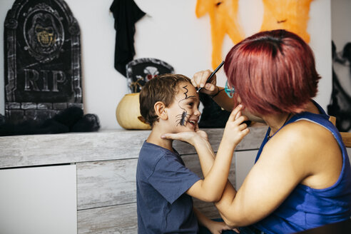 Mother painting her son's face for Halloween - JRFF01899