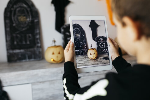 Kleiner Junge fotografiert Halloween-Dekoration mit digitalem Tablet - JRFF01900