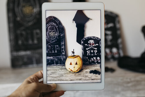 Mann fotografiert Halloween-Dekoration mit digitalem Tablet - JRFF01901