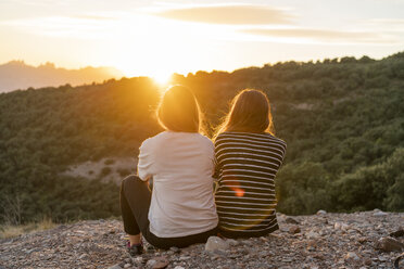 Freunde beobachten den Sonnenuntergang von einem Berg aus - AFVF01651