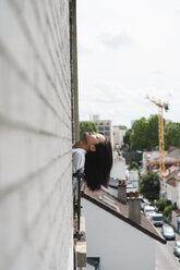 France, Paris, young woman leaning her head out of the window - AFVF01658