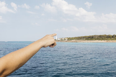 Frauenhand, die auf den Leuchtturm von Cap Balnc zeigt, Mallorca, Spanien - JRFF01904